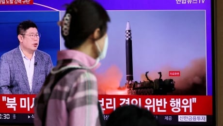 FILE PHOTO: A woman watches a TV broadcasting a news report on North Korea's launch of three missiles including one thought to be an intercontinental ballistic missile (ICBM), in Seoul, South Korea, May 25, 2022.