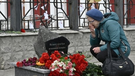 Local resident Tetyana, 67, reacts as she visits to lays flowers at a memorial near the train station in Kramatorsk, in the Donetsk region, on April 8, 2023, amid the Russian invasion on Ukraine. - Ukrainians in the eastern city of Kramatorsk on April 8 laid flowers at a small memorial at the central train station one year after Russian missiles hit the transport hub killing dozens. The strikes on April 8, 2022 killed 61 people and injured more than 160 bystanders in one of the single deadliest attacks of the war that targeted civilians fleeing Russia's advance.